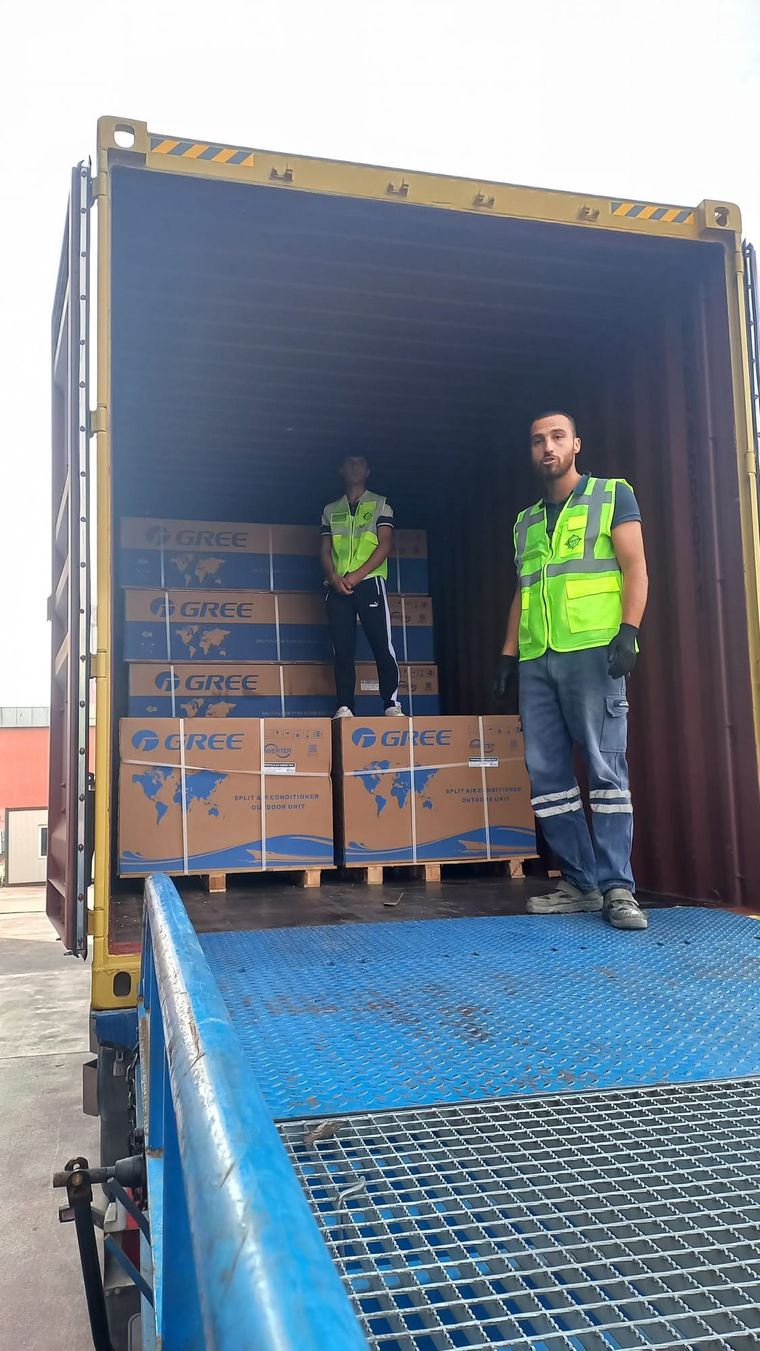 Konteyner ağzında mobil rampa üzerinde duran REGT personeli, içeride paletli koliler